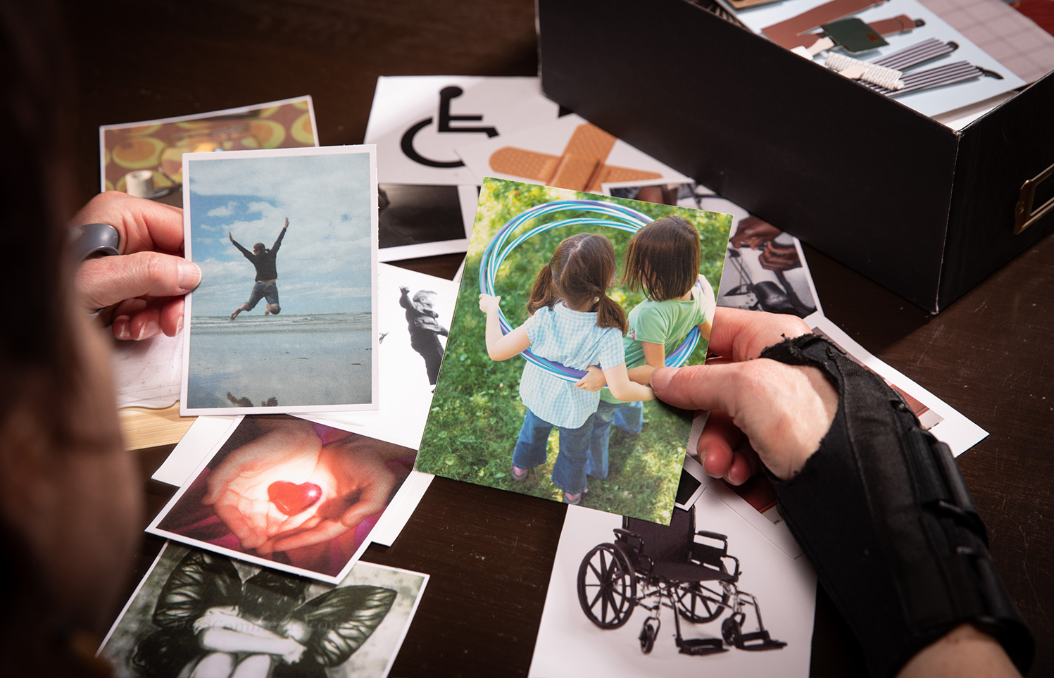 Image of hands collecting card box photos to show pain history