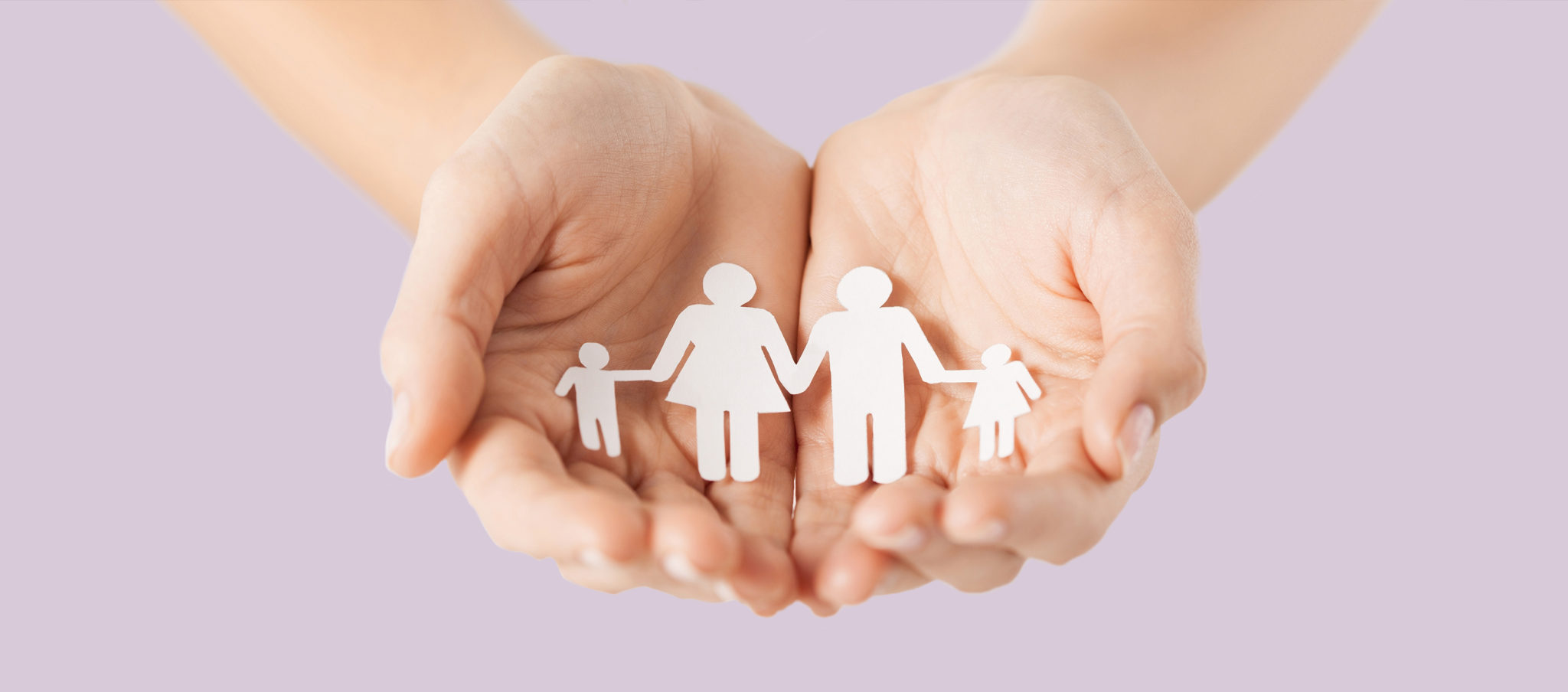 Image of hands holding paper cut-out of family